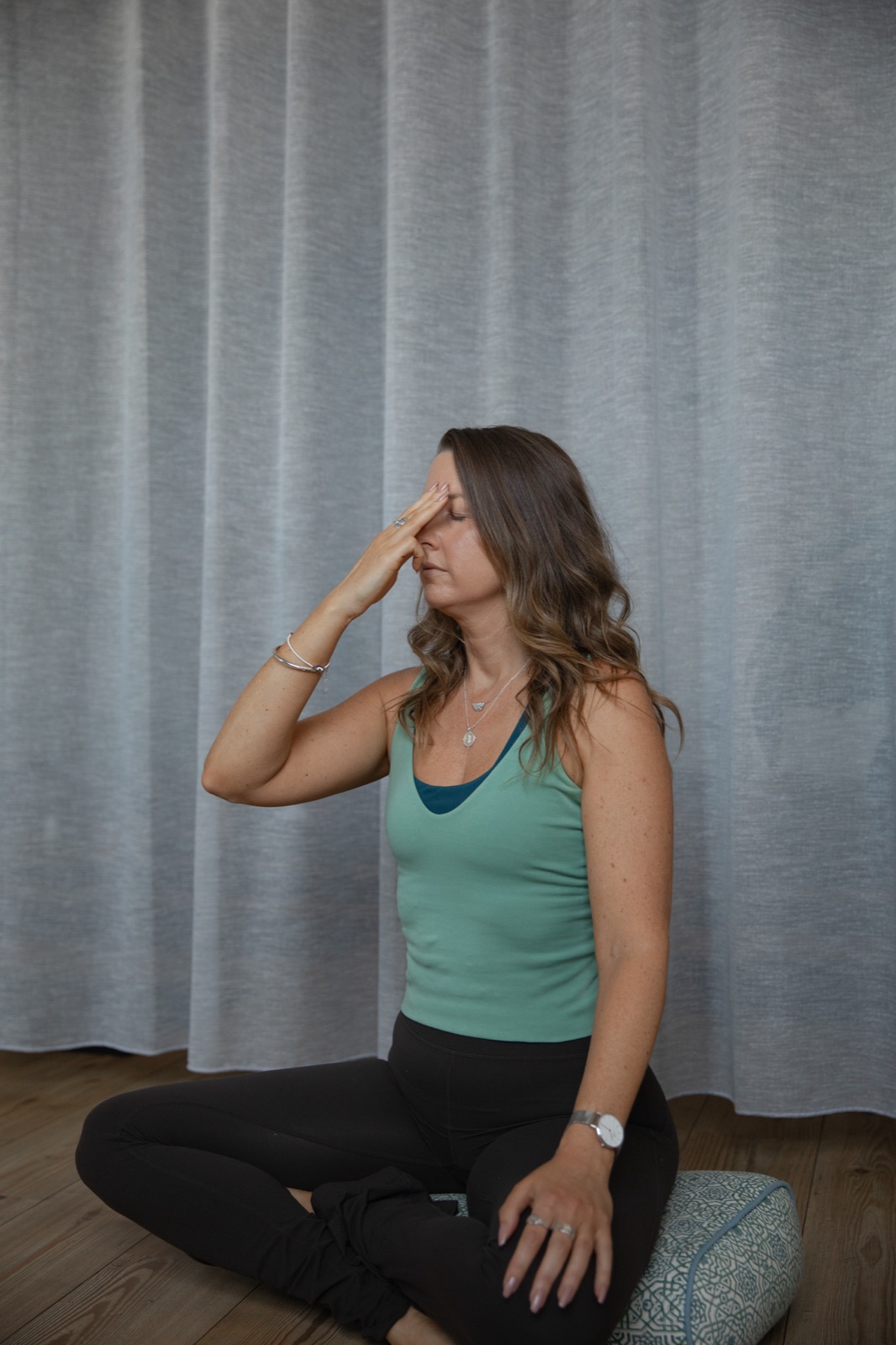 Kim Yates seated cross-legged, practising alternate nostril breathing
