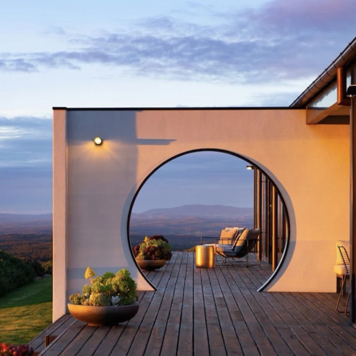 A round archway on a deck overlooking rolling hills near Daylesford at sunset